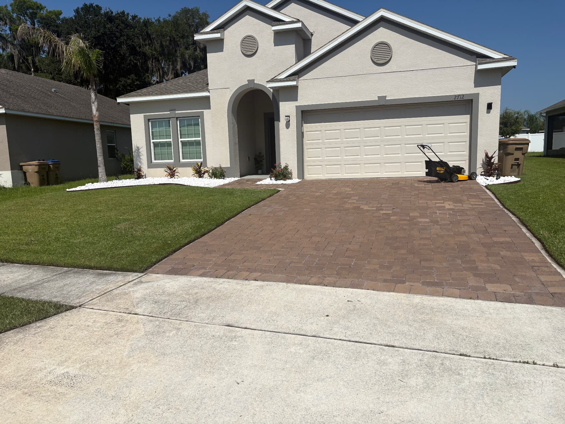 Freshly mowed front lawn with clean edging and white rock beds in Kissimmee